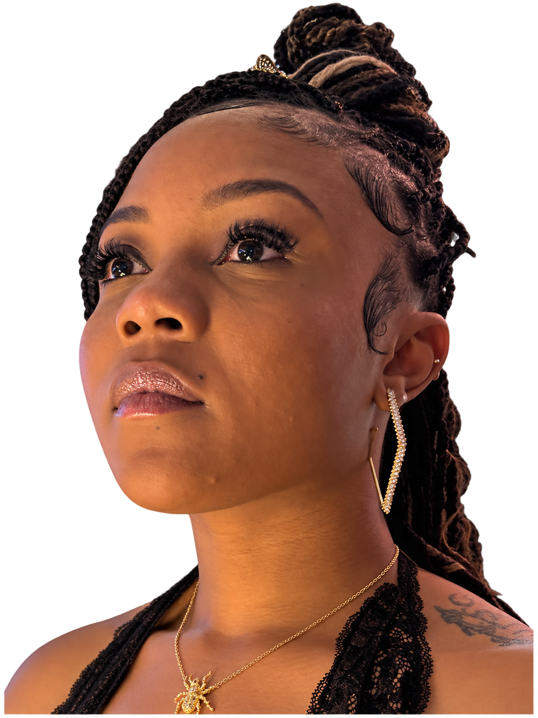 A close-up of Daisha with braided hair and gold jewelry